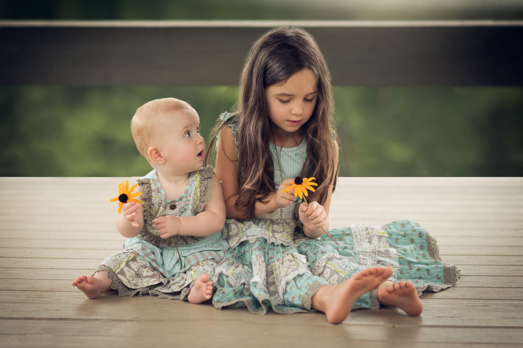 choosing a family photographer to photograph two sisters in matching dresses