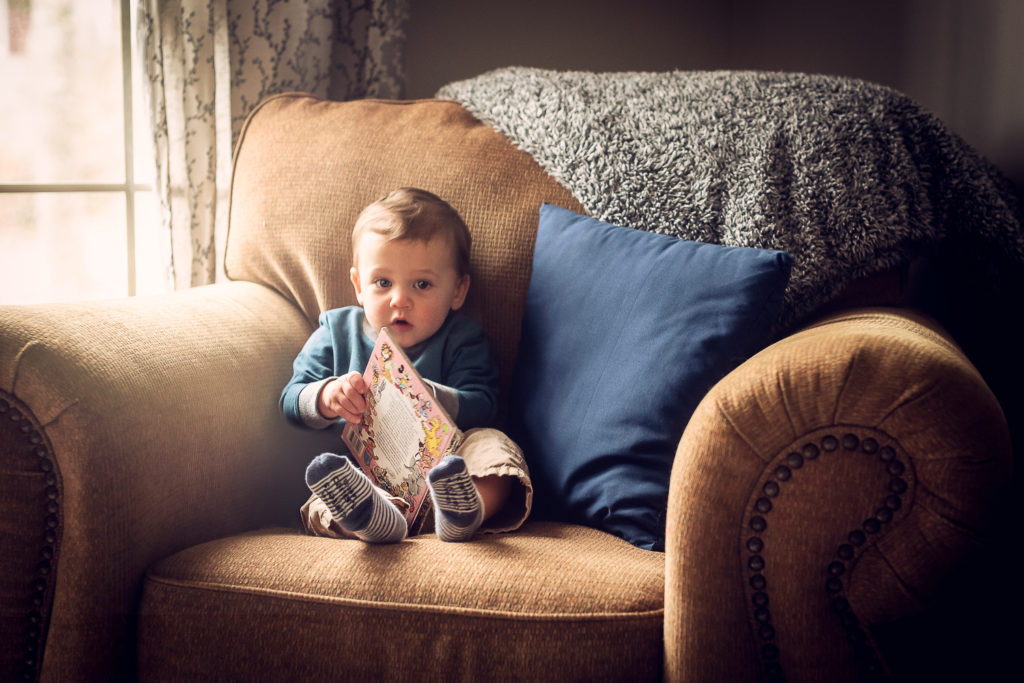child reading book by window